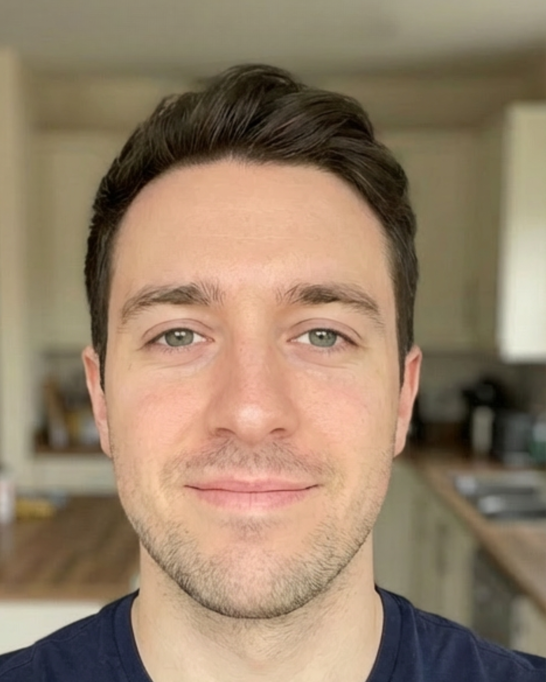Smiling person in a kitchen background.