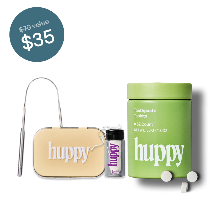 Dental hygiene kit with toothpaste tablets, floss, tongue cleaner labeled 'huppy'.