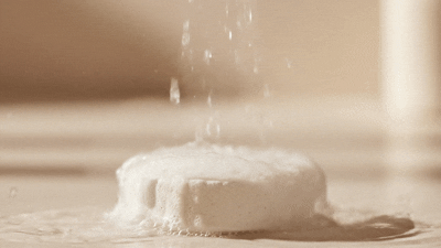 Water flows onto a fizzing tablet, creating bubbles.