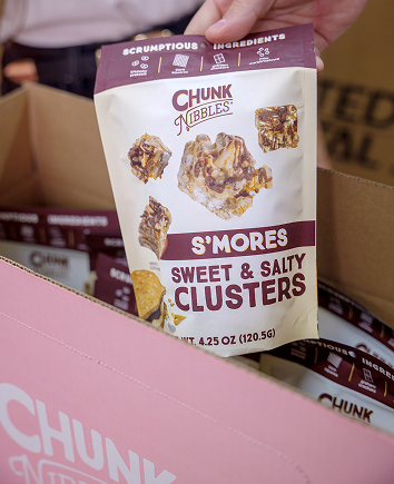 Bag of Chunk Nibbles S'mores Sweet & Salty Clusters held by a person.