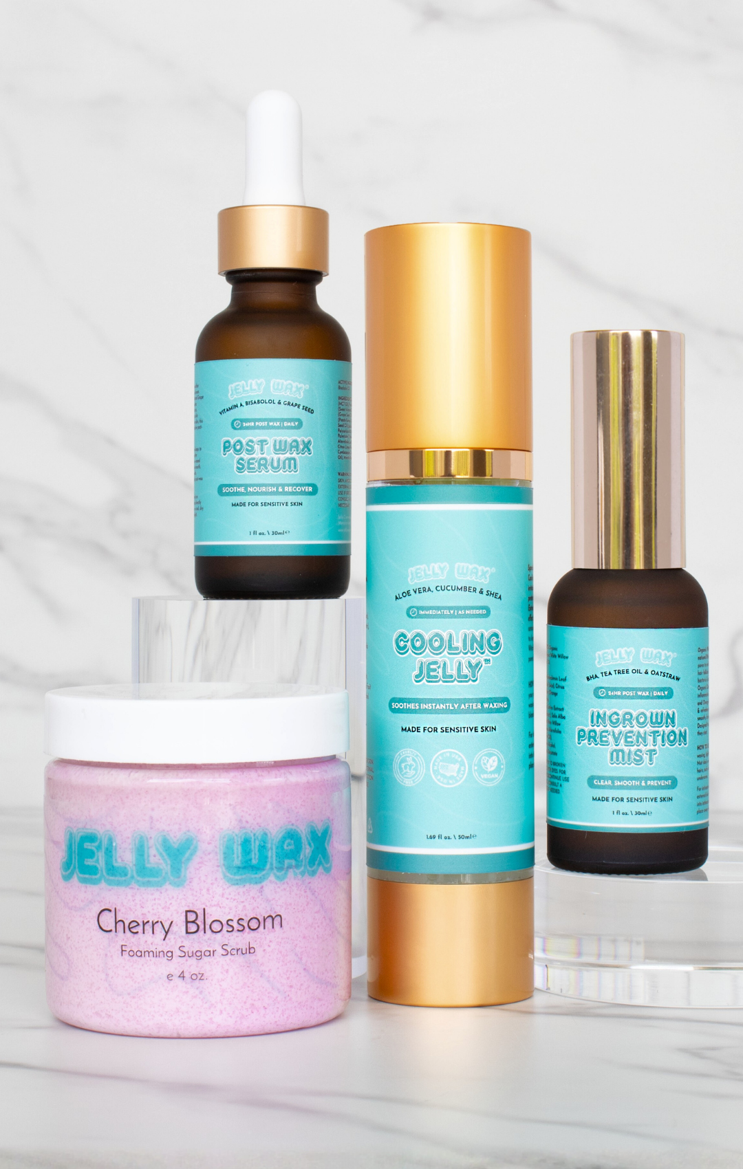 Four skincare products on a marble surface.