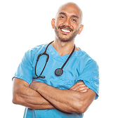 A smiling man in blue scrubs with a stethoscope around his neck, standing with his arms crossed.