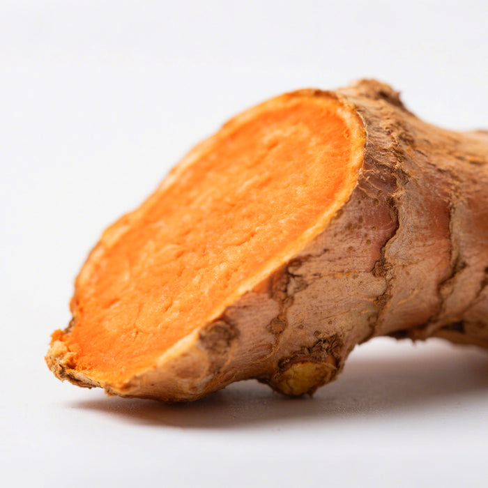 Close-up of a sliced orange root vegetable on a white background.