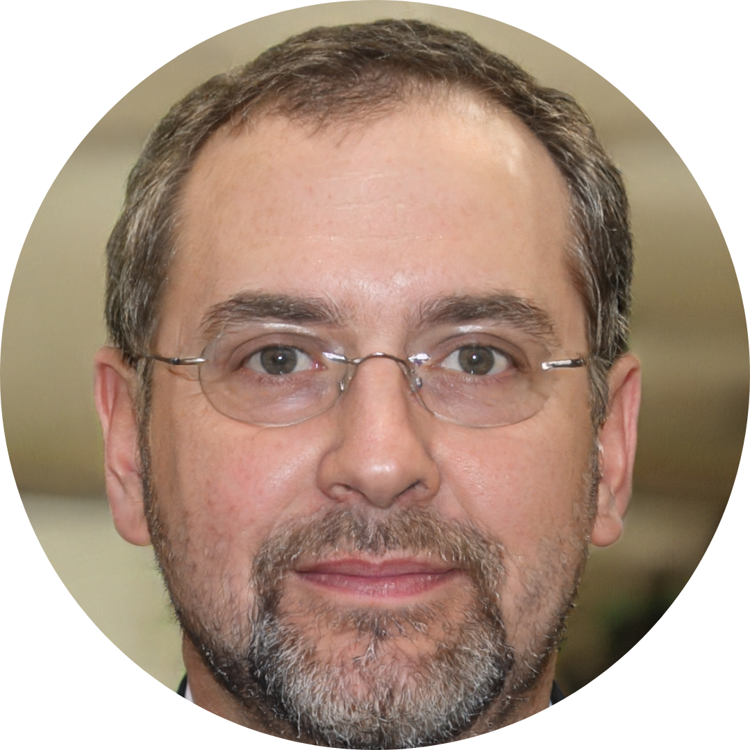 A circular headshot of a middle-aged man with glasses and a salt-and-pepper goatee.