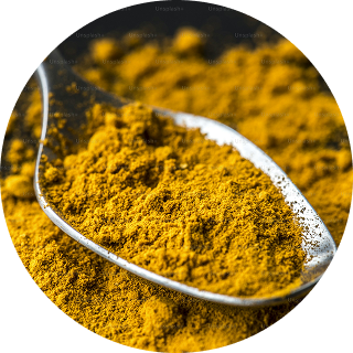 A spoonful of yellow spice powder on a dark surface.