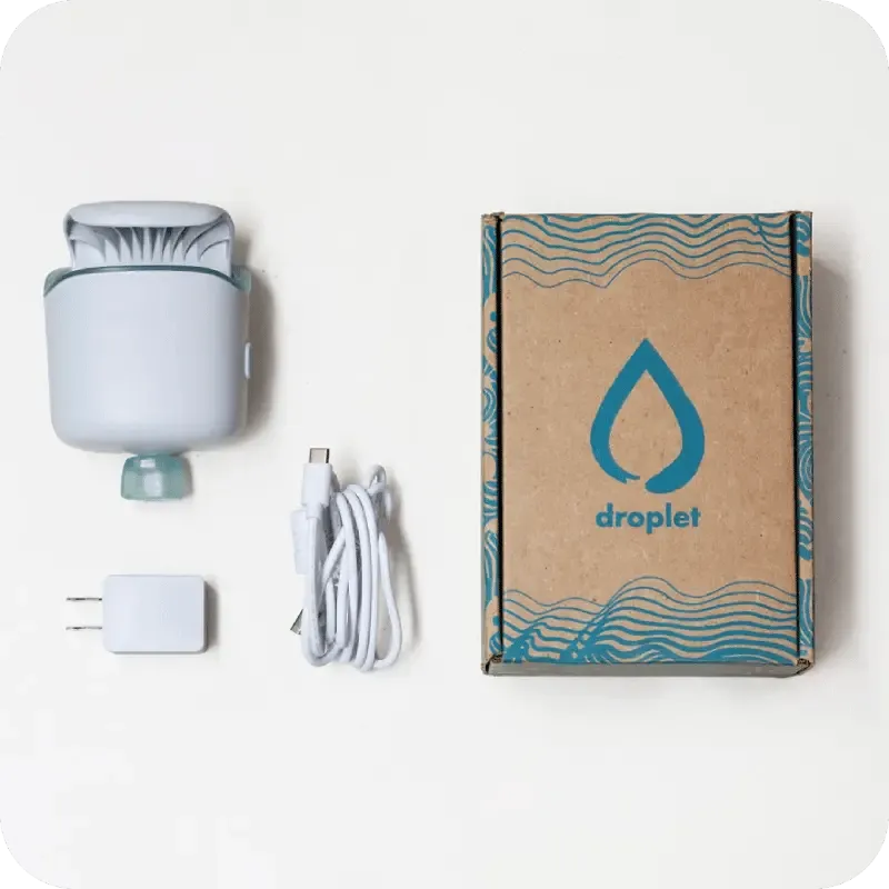 A light blue device, its packaging, a USB cable, and a wall adapter on a white surface.