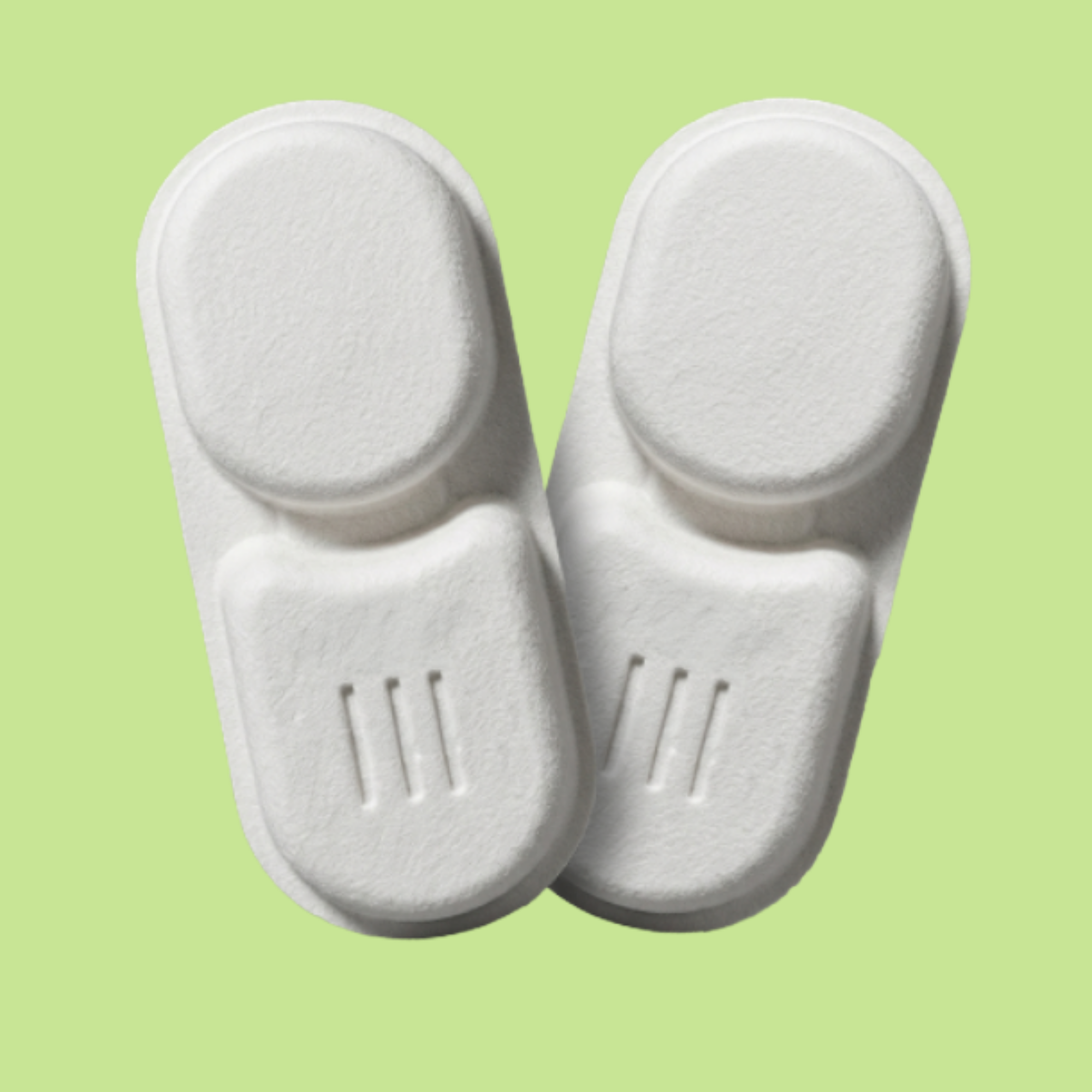 Two white, molded pulp packaging inserts with indentations, against a light green background.