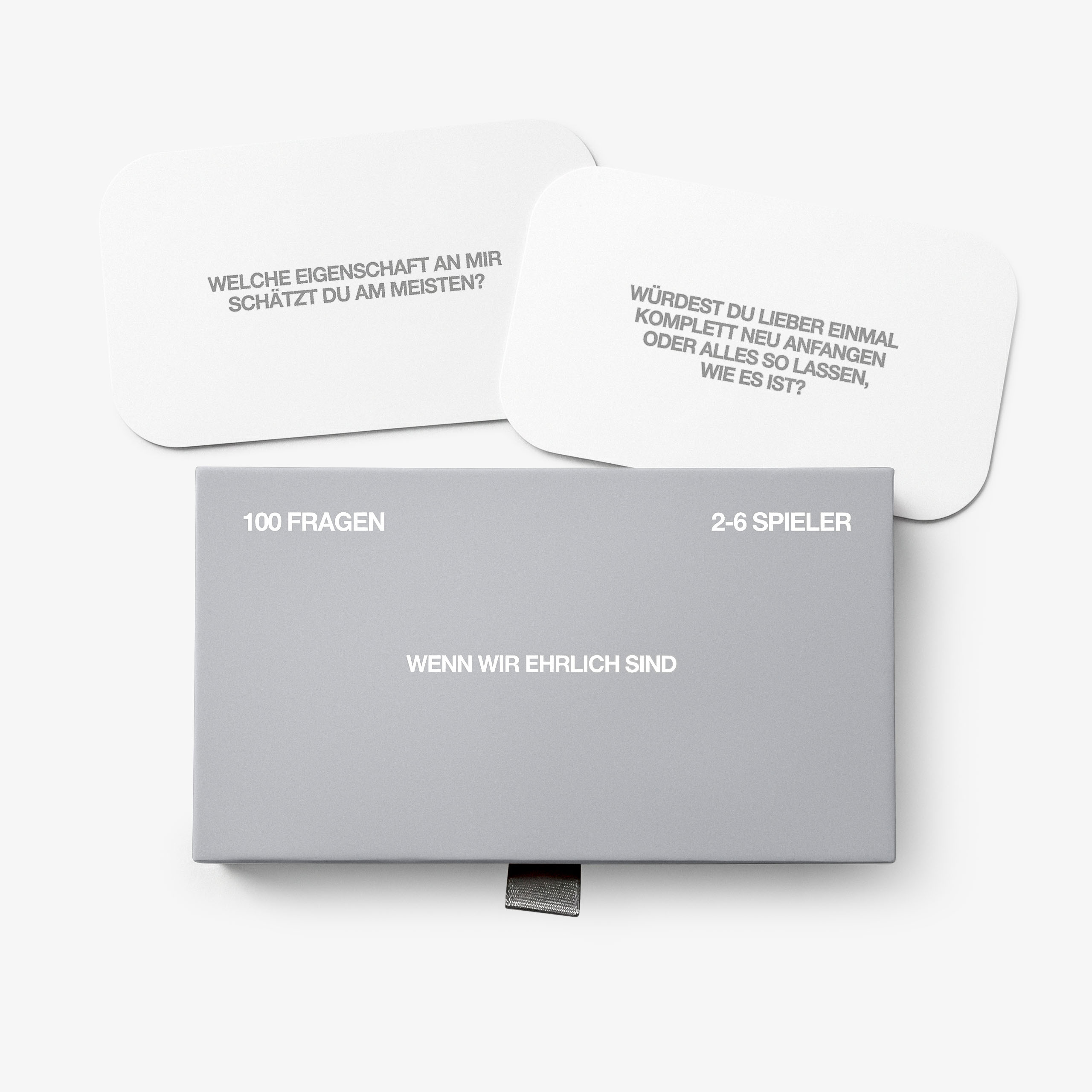 A grey box and two white cards for the German card game 'Wenn wir ehrlich sind'.