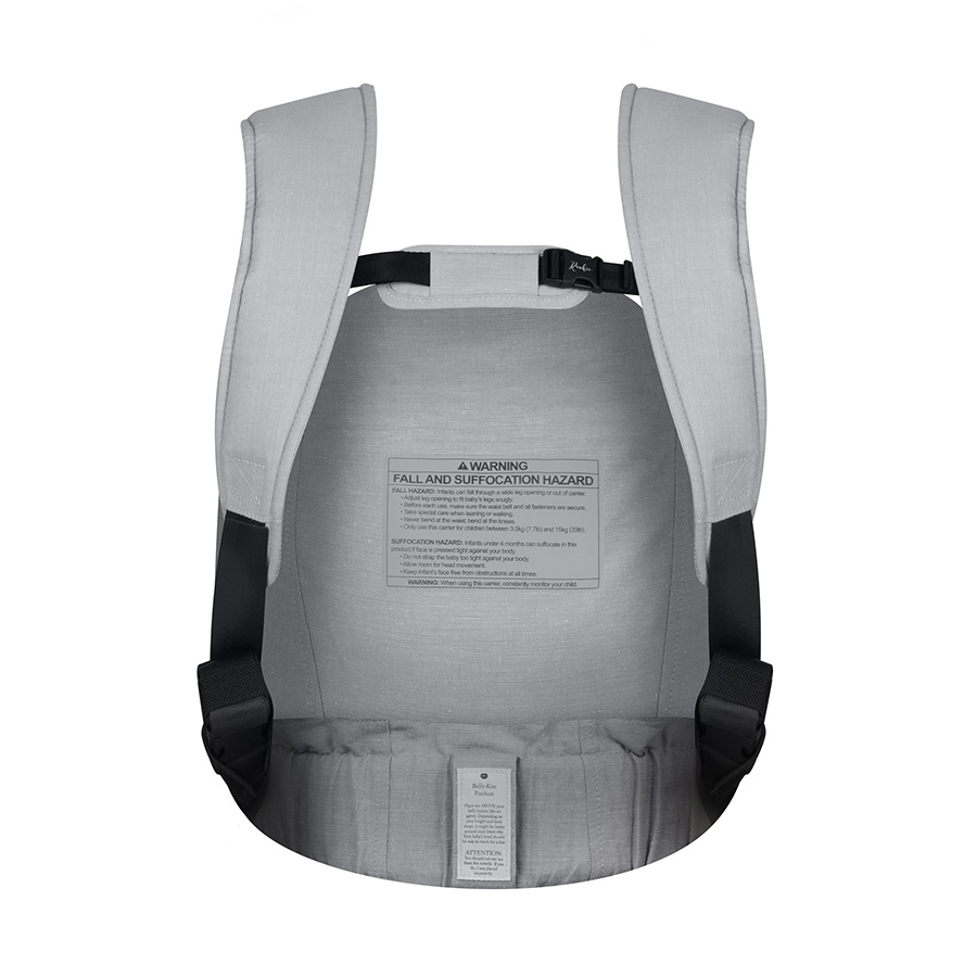 The inside of a light gray baby carrier showing the shoulder straps and a prominent warning label.