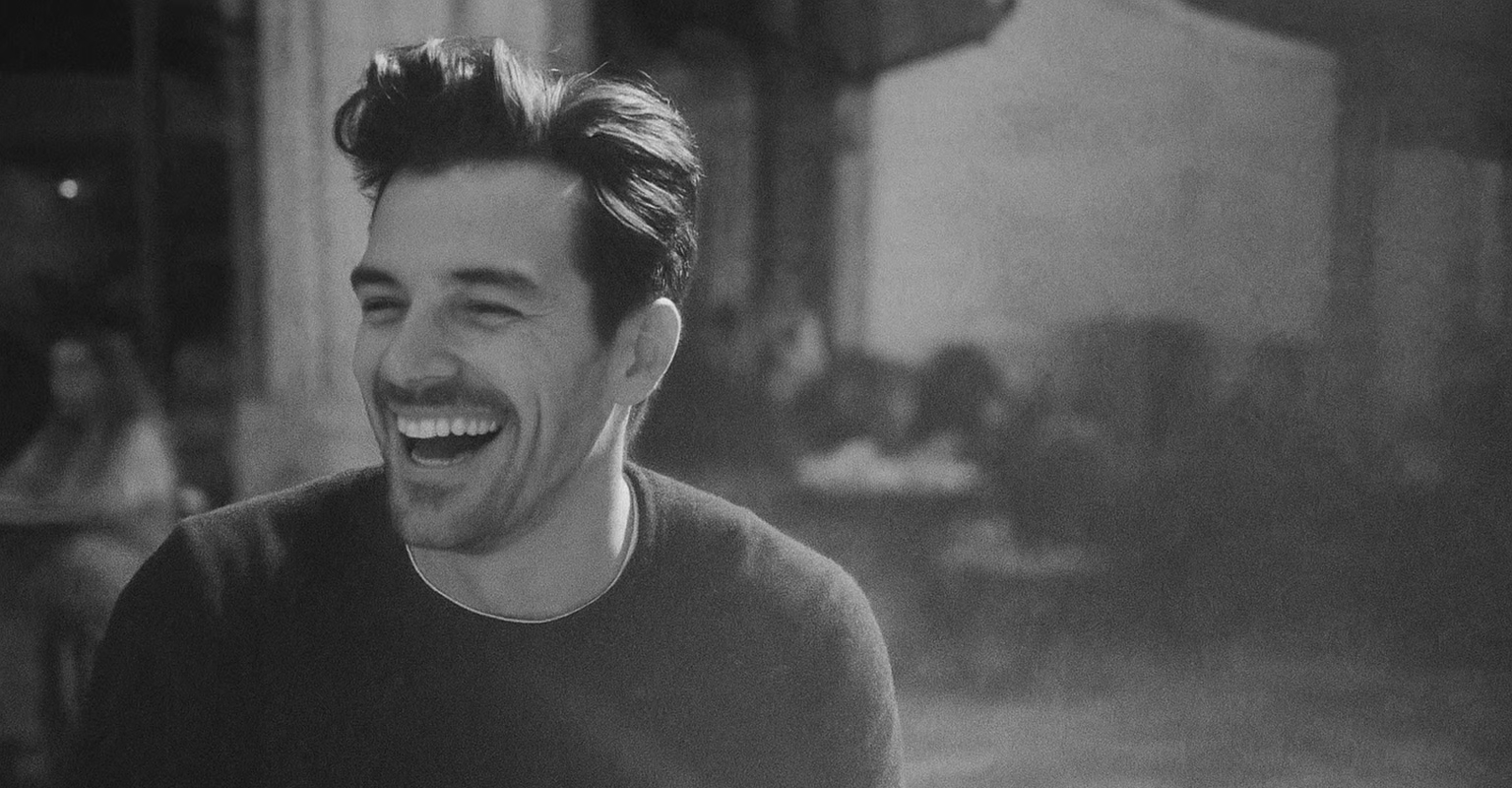 Black and white photo of a man laughing.