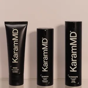 Three black containers of KaramMD skincare products: a cleanser, a serum, and a cream.