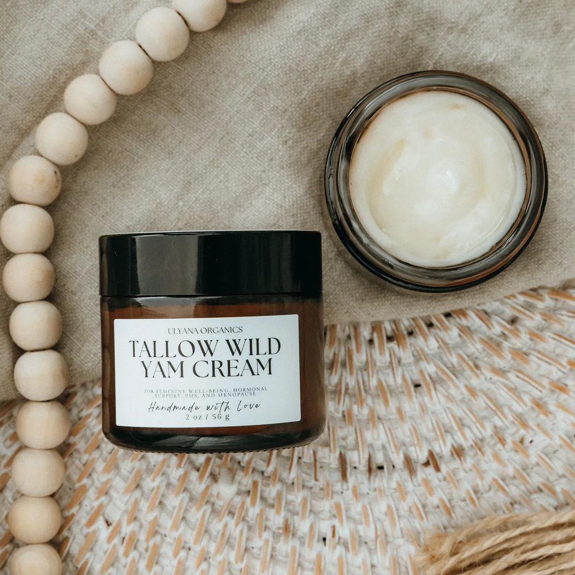 Two jars of Tallow Wild Yam Cream on a woven surface.