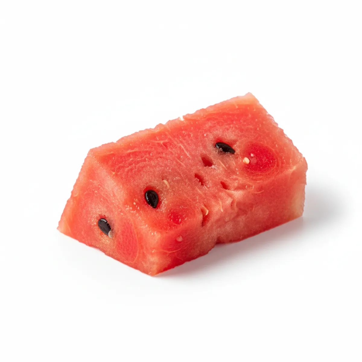 A single chunk of red watermelon with black seeds, cut into a blocky shape on a white background.
