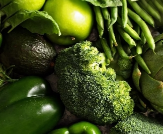 Assorted green vegetables including broccoli, bell peppers, and apples.
