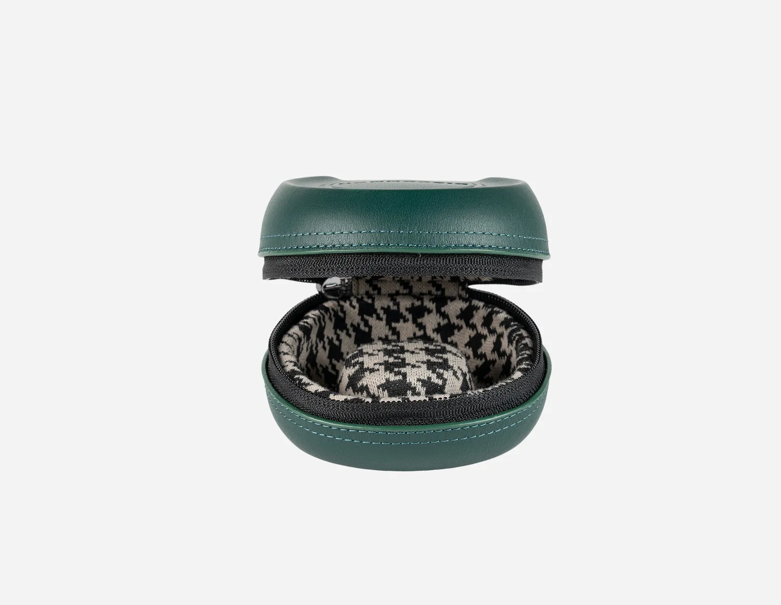 An open, round, green zippered case with a black and white houndstooth patterned interior against a white background.