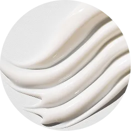 A close-up of thick, white cream applied in wavy lines inside a circular frame.
