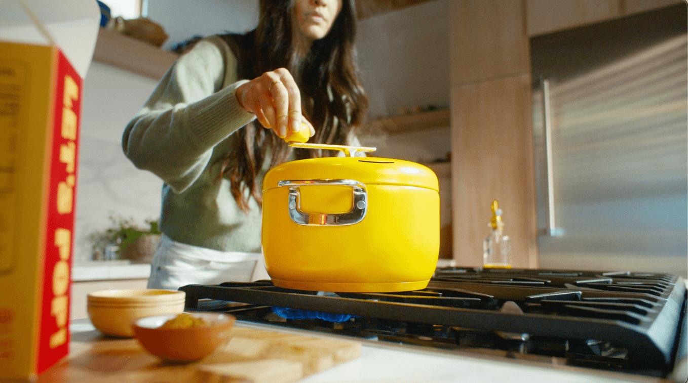 Hands using The Popper on the stove