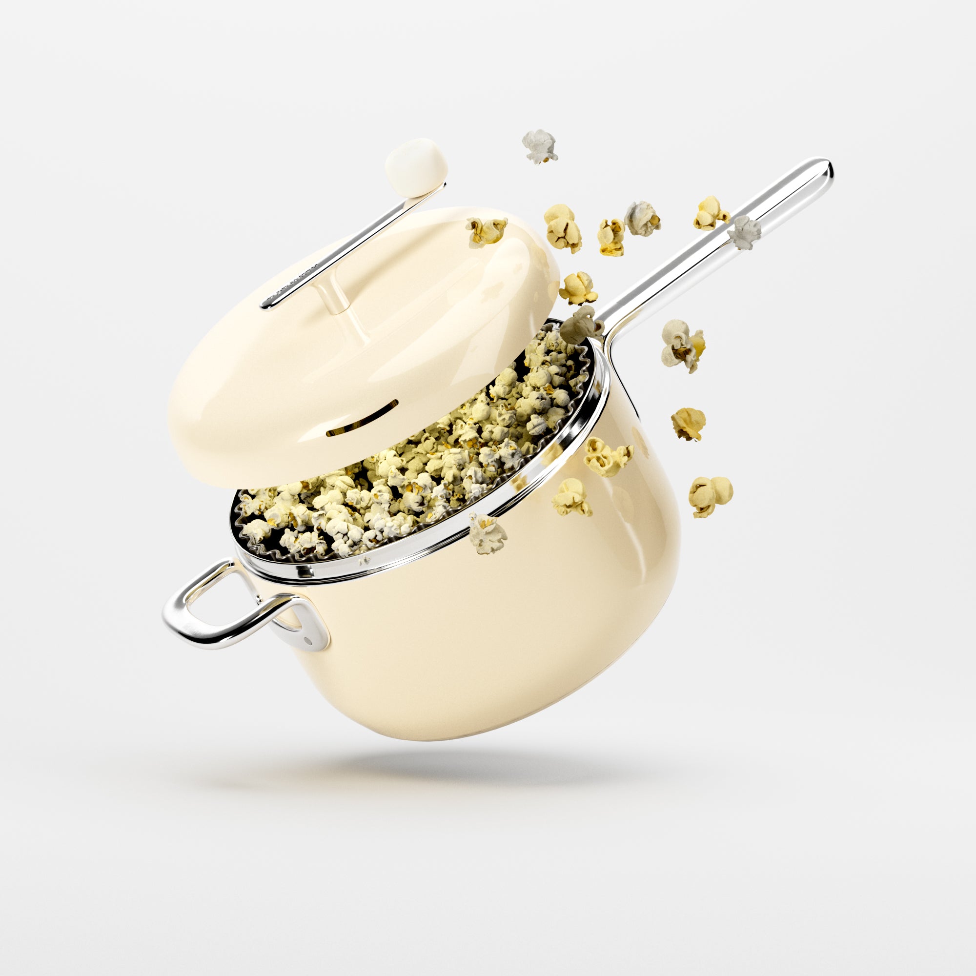 A cream-colored saucepan floats in mid-air, overflowing with popcorn against a white background.