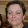 A person with short hair smiling slightly.