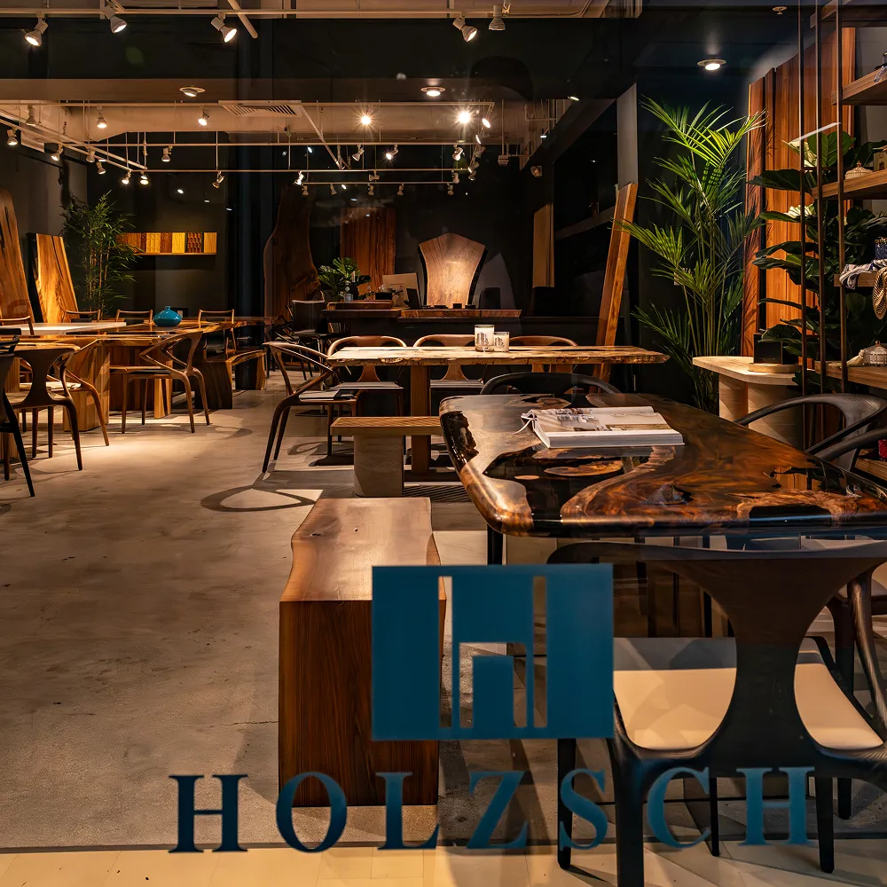 A well-lit showroom displaying a variety of modern, live-edge wooden tables, benches, and chairs.