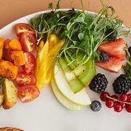 Plate with assorted fruits, vegetables, and greens.
