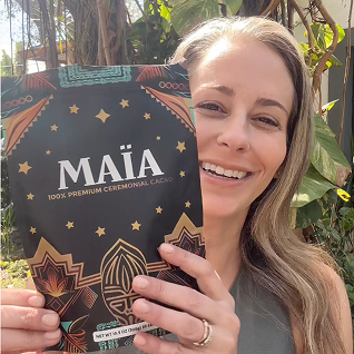 Person holding a Maia ceremonial cacao package outdoors.