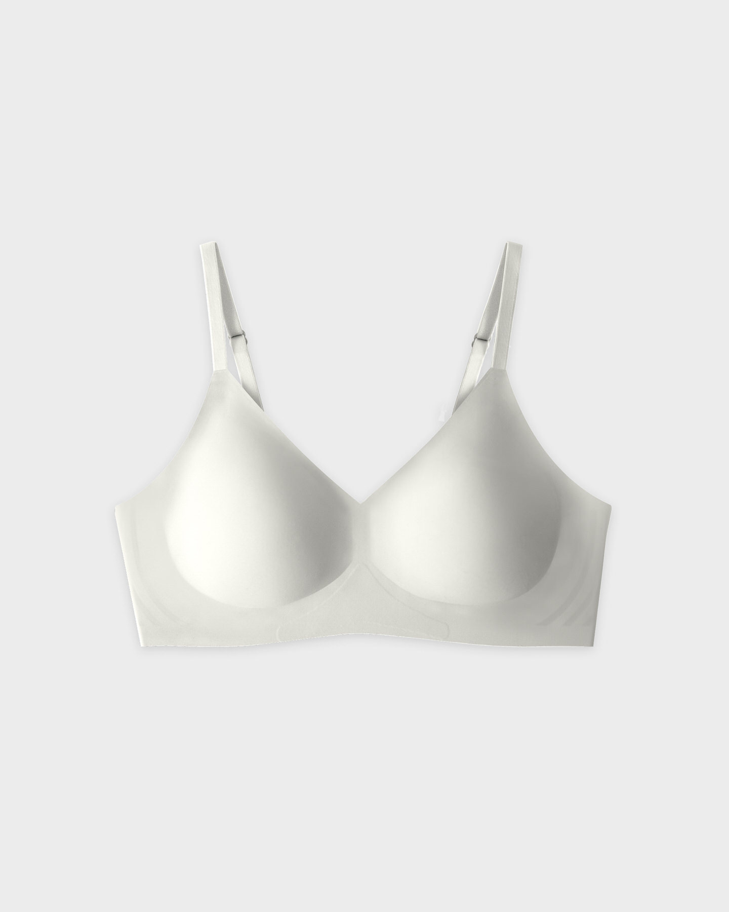White seamless bra with adjustable straps on a plain background.