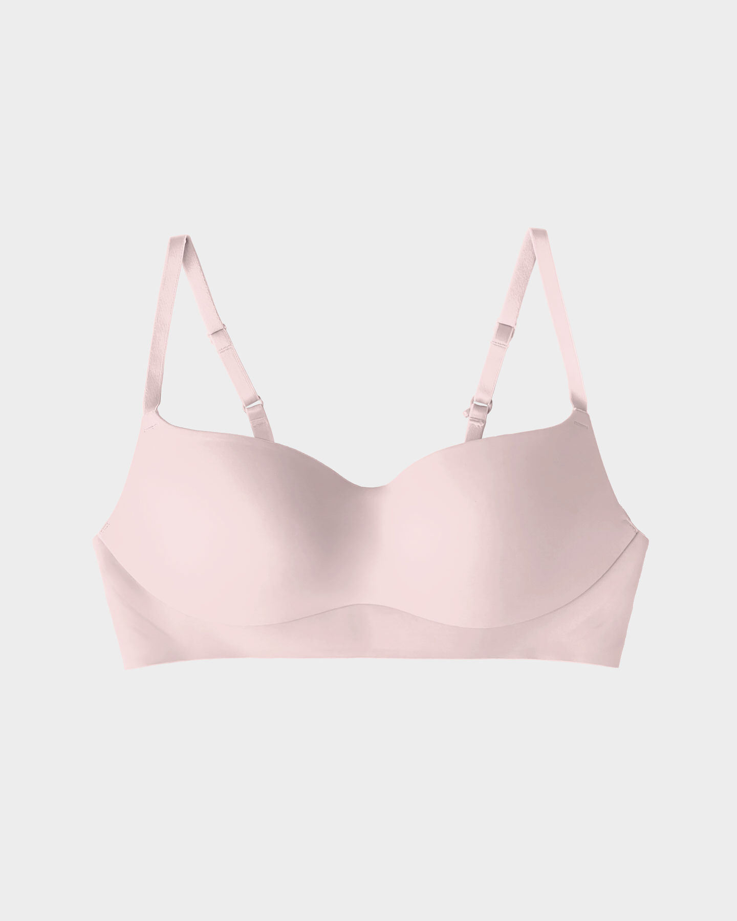 Beige seamless bra with adjustable straps on a white background.