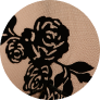 A close-up of a black floral lace pattern on a tan background, shown in a circle.