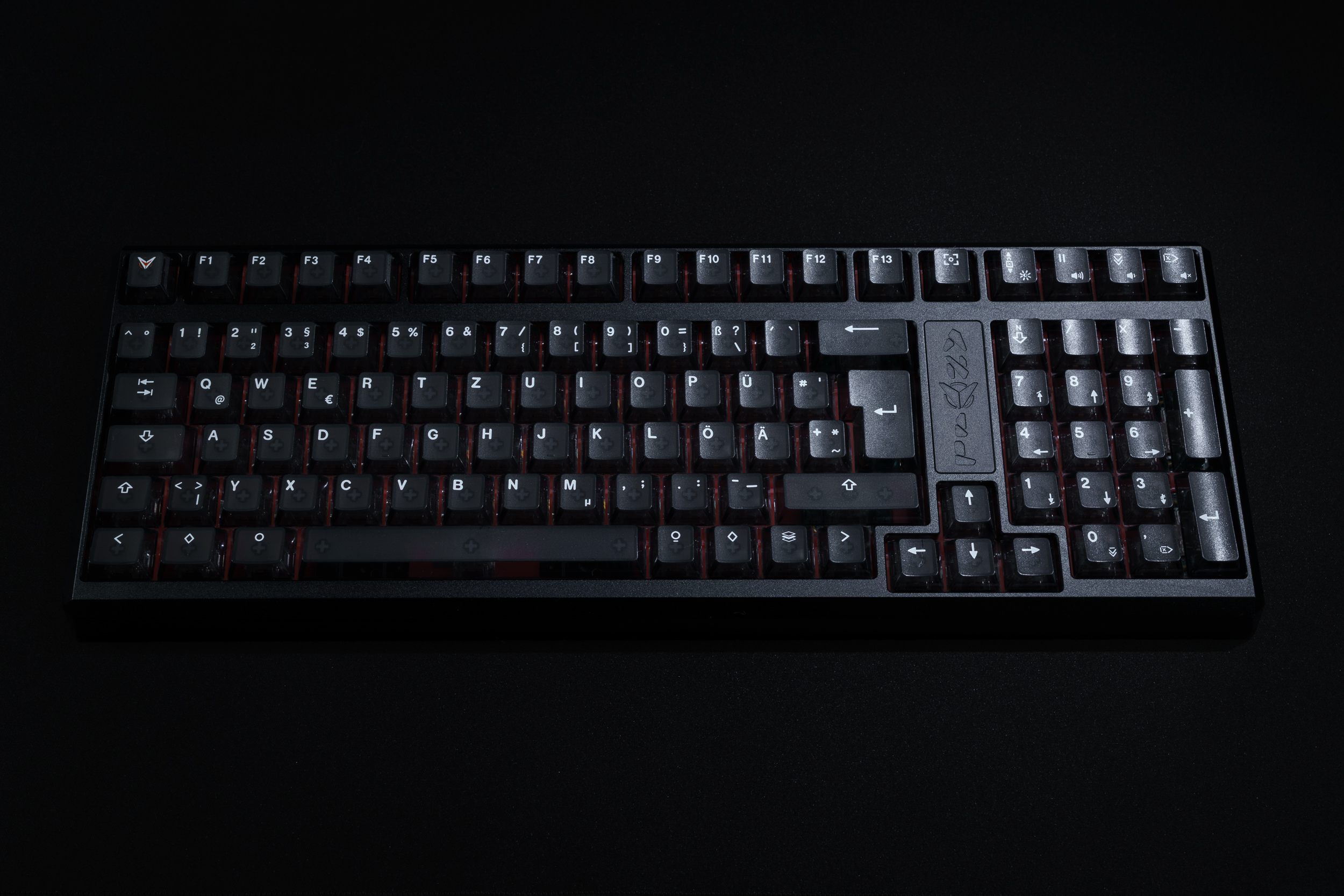 A full-sized black computer keyboard with white lettering, photographed from above on a black background.