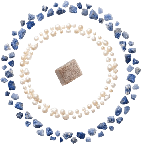 A brown stone surrounded by concentric circles of white pearls and blue stones on a white background.
