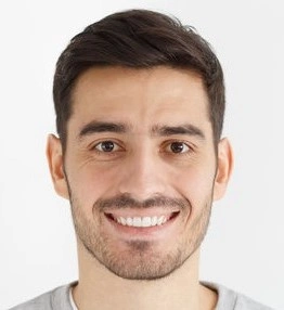 Smiling person with short dark hair against a plain background.