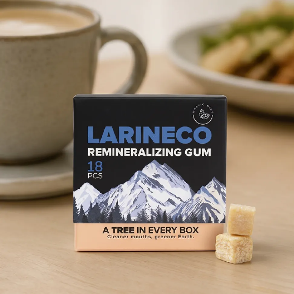 A box of Larineco Remineralizing Gum sits on a wooden table next to two pieces of the gum.