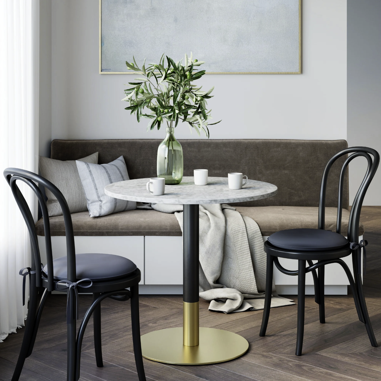 Modern dining area with round table, two chairs, and a vase with greenery.