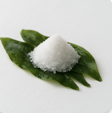 Pile of coarse salt on green leaves on a white background.