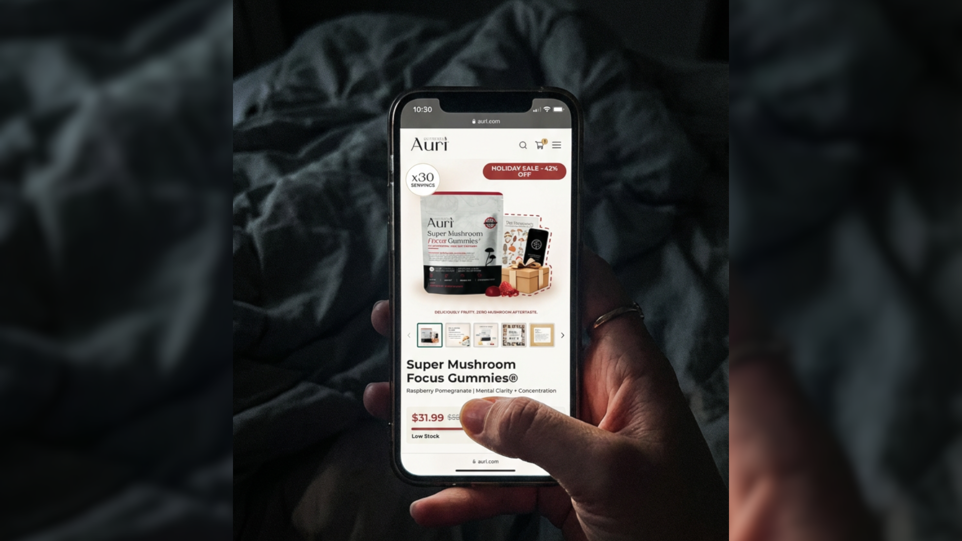 Hand holding a smartphone displaying a webpage for mushroom focus gummies.