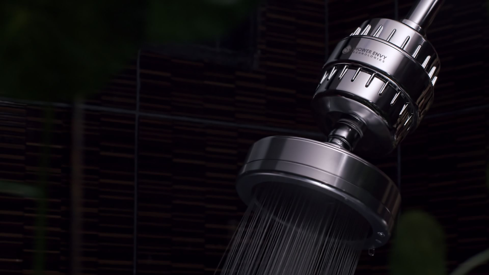 Close-up of a chrome showerhead with water flowing.