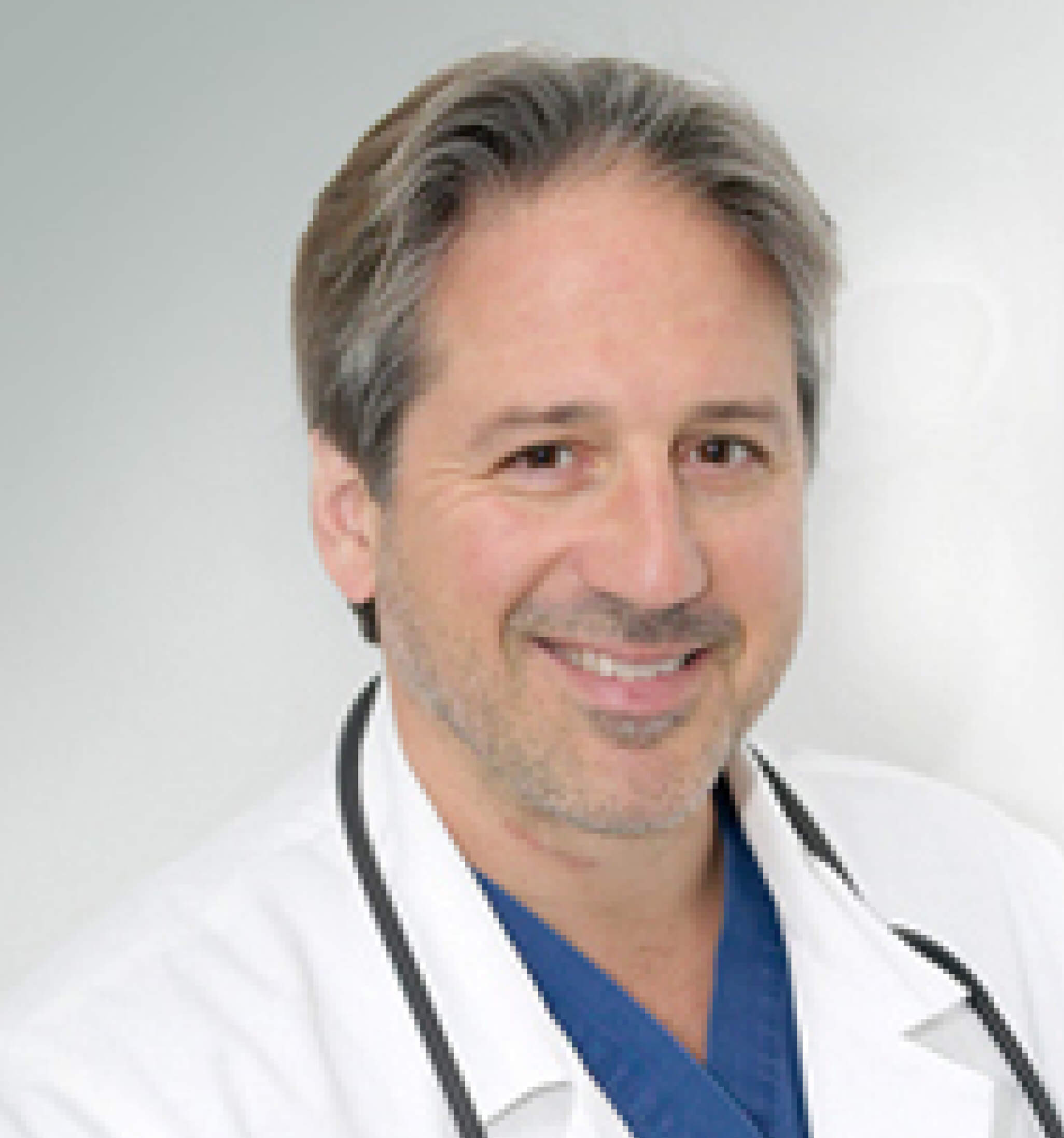 Smiling person in a white coat with a stethoscope.