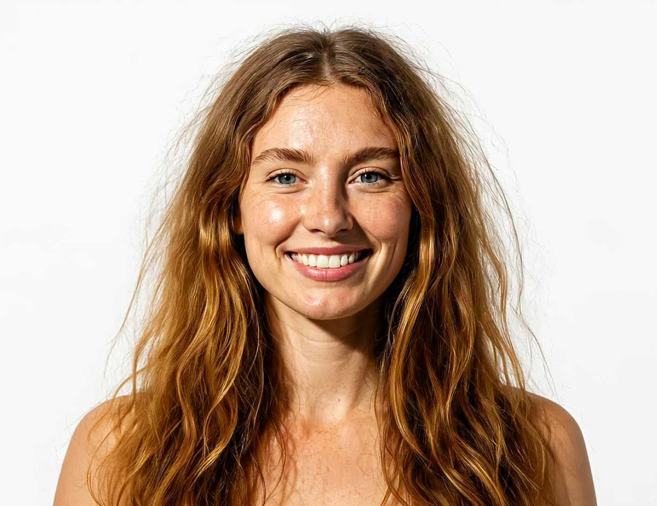 Smiling person with long wavy hair against a plain background.