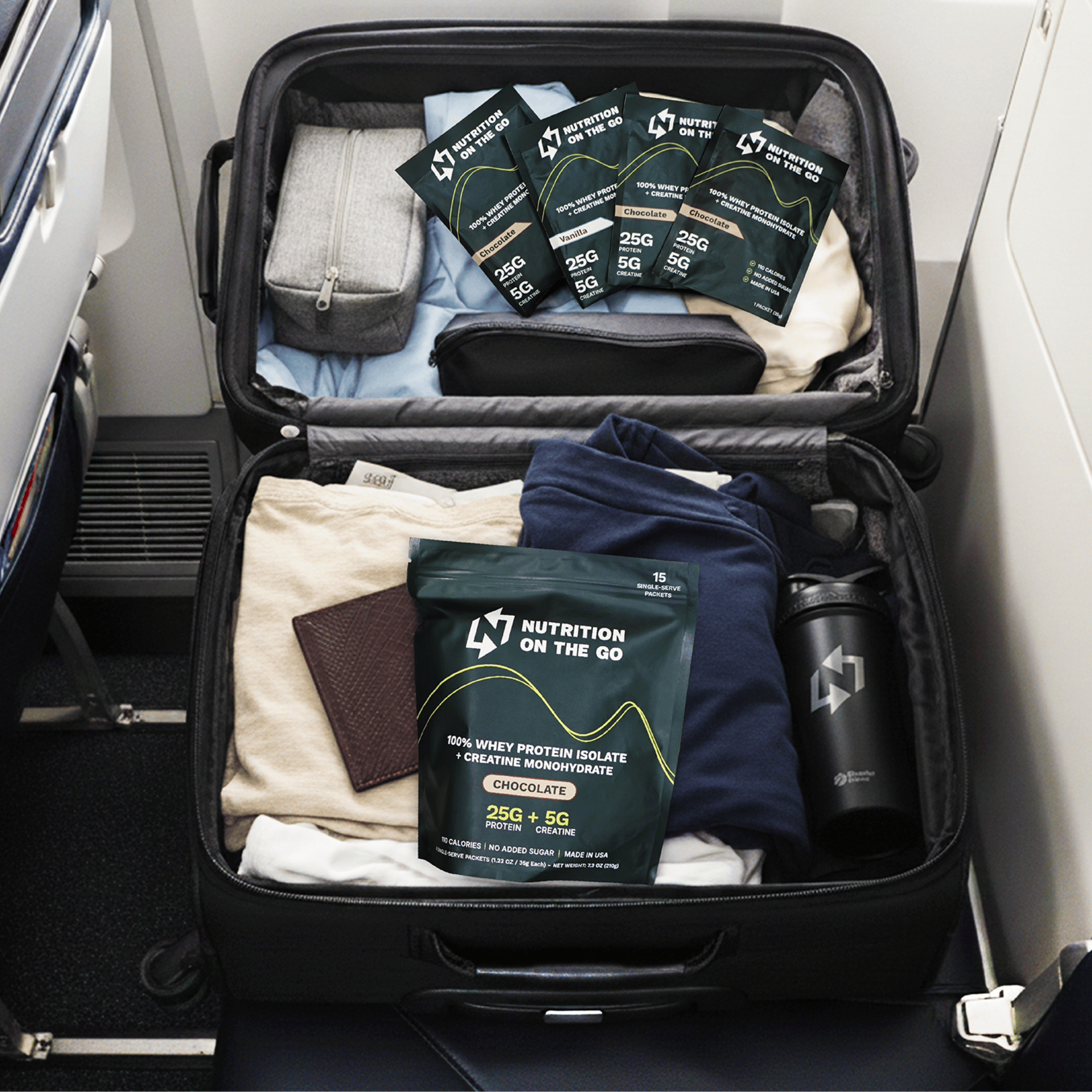 An open suitcase on an airplane seat, packed with clothes and Nutrition on the Go protein powder.