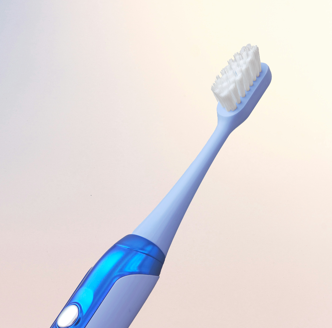 Electric toothbrush with blue and white design on a light background.