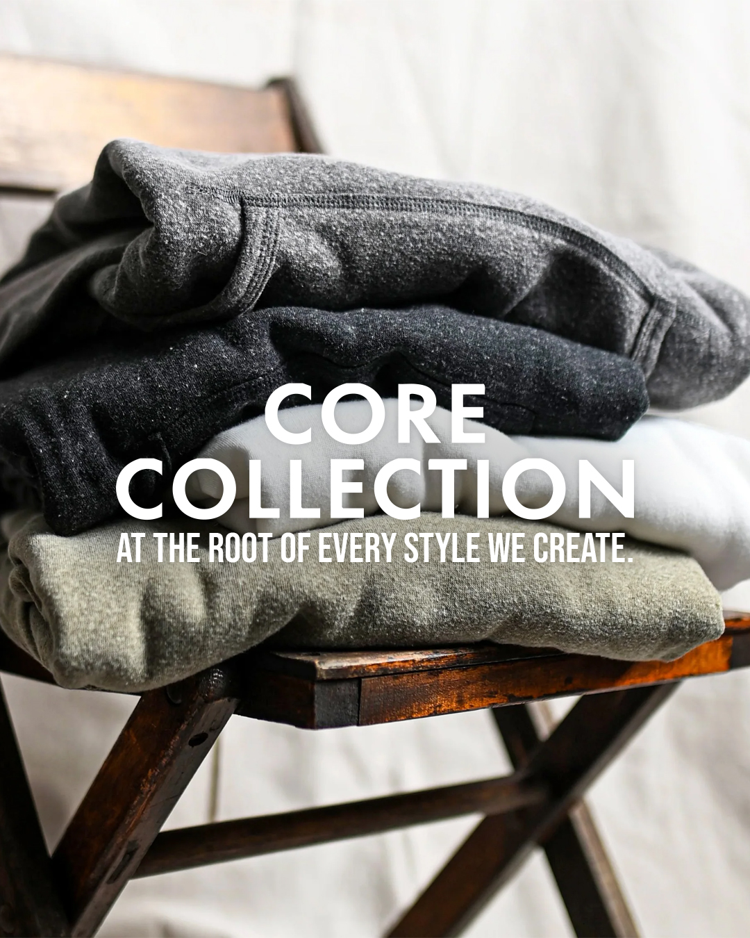 Folded clothes on a wooden chair with 'CORE COLLECTION' text.