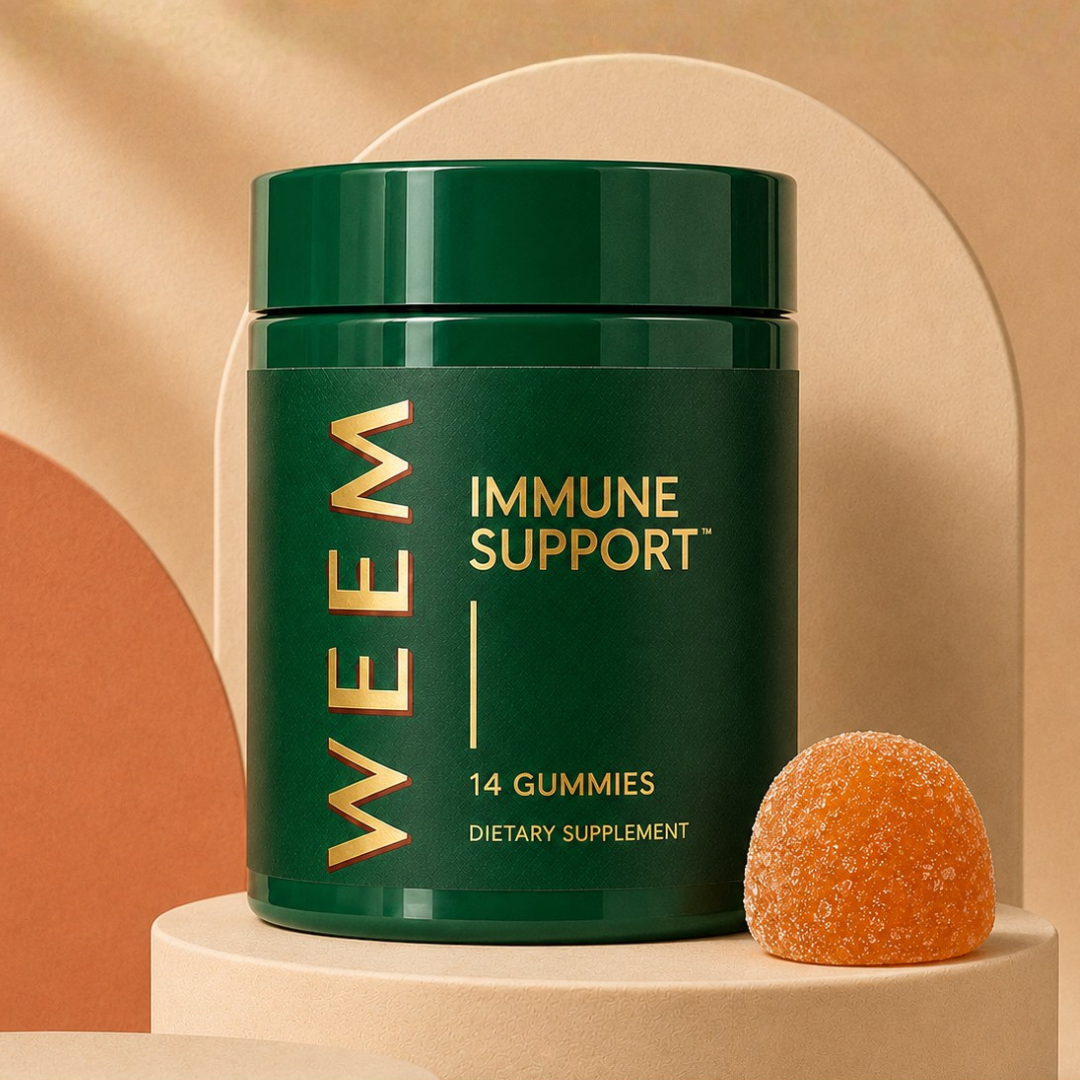 A green bottle of WEEM Immune Support dietary supplement gummies next to a single orange, sugar-coated gummy.