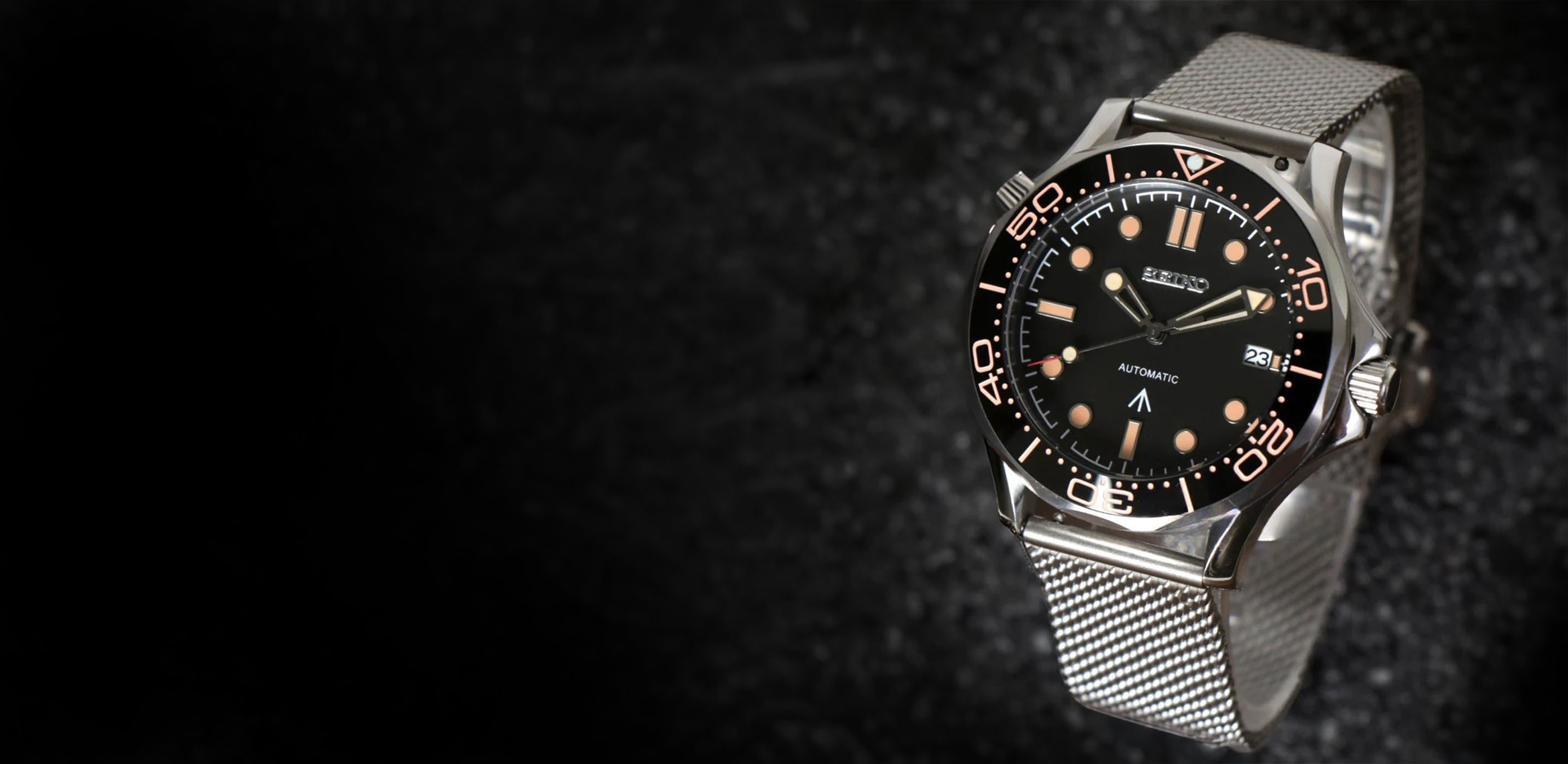 Silver automatic watch with a black dial, showing date and time.