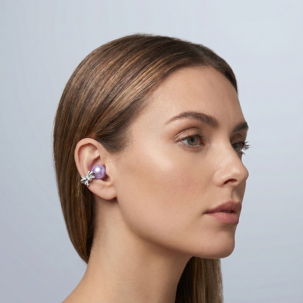 A woman in profile wears a large lavender pearl ear cuff with a silver bow.