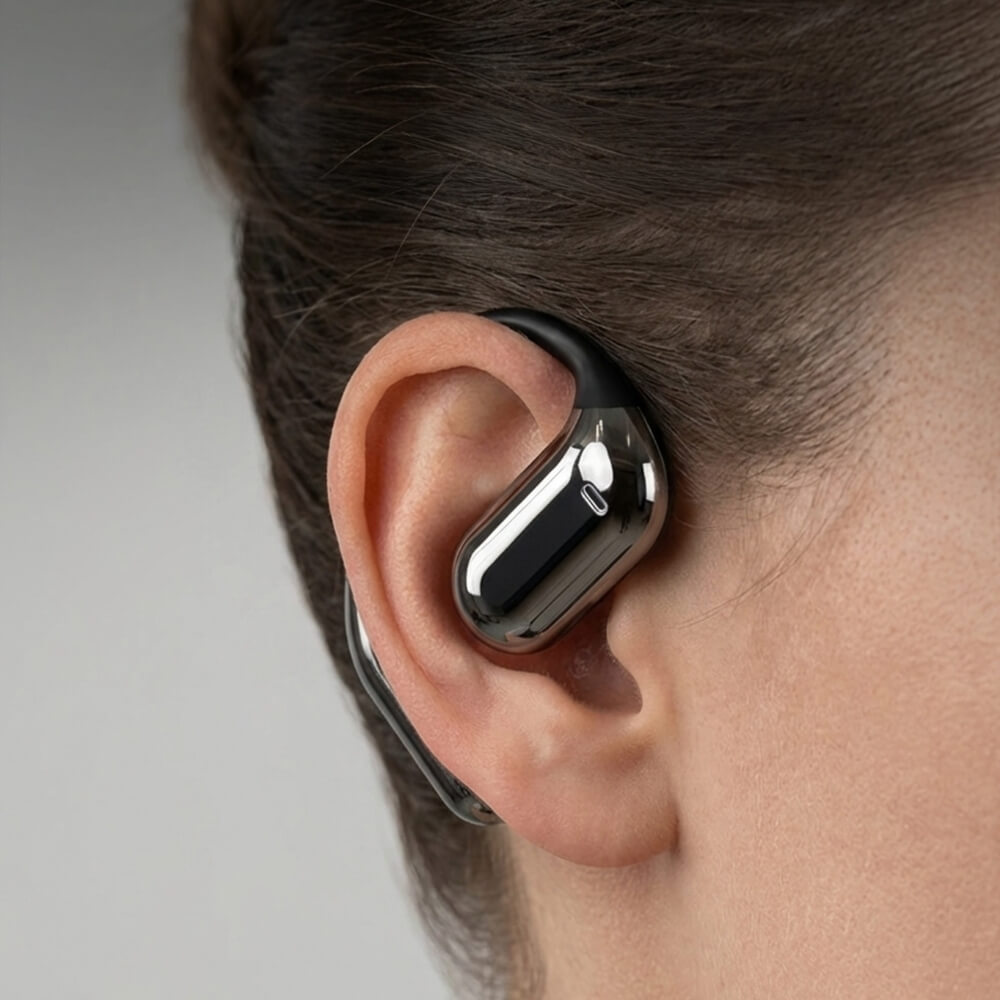 A close-up of a person wearing a shiny, metallic over-the-ear earbud.