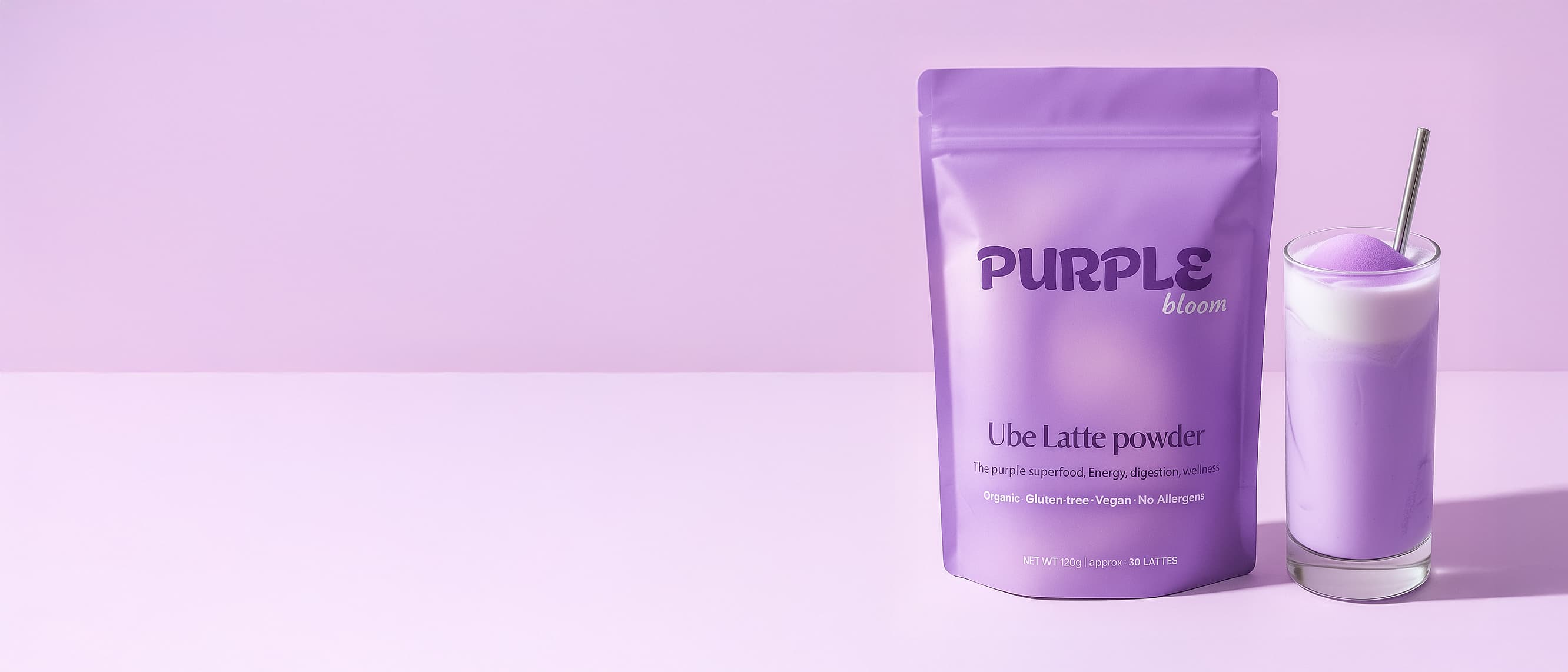 Purple ube latte powder package and glass with purple drink on pink background.