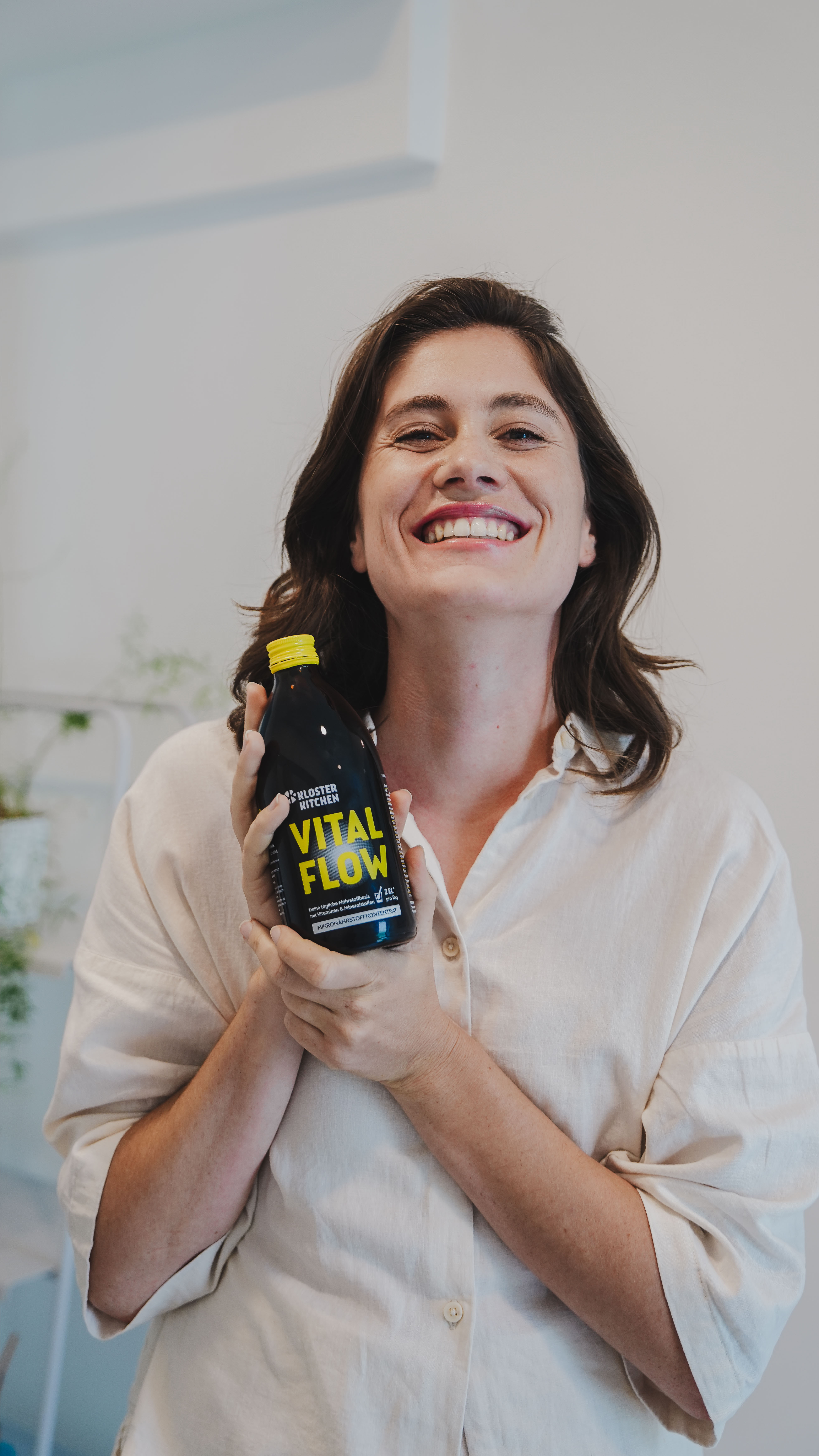 Persona sonriendo y sosteniendo una botella con la etiqueta "Vital Flow".