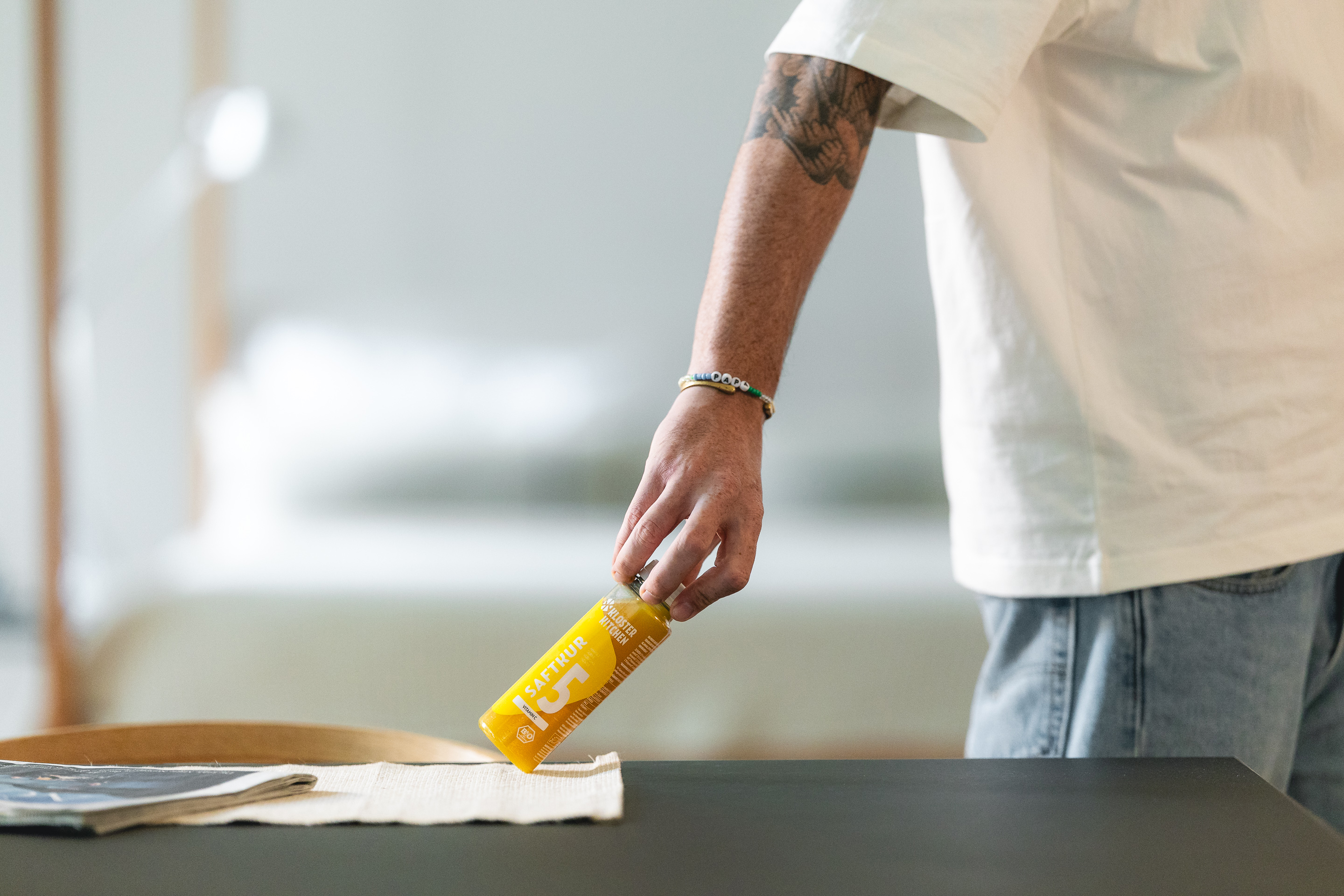 Person placing a yellow beverage can on a table.