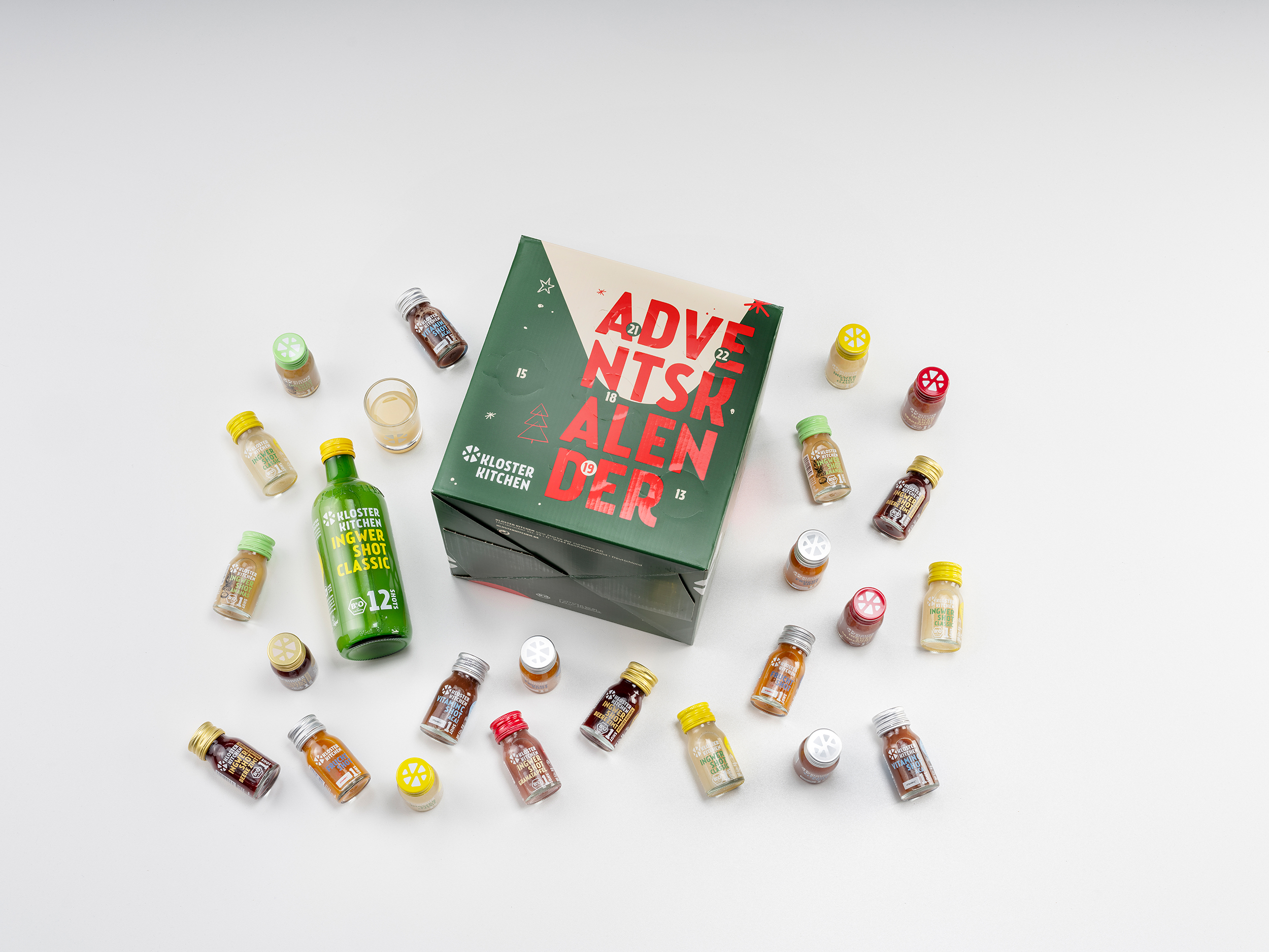 Assorted small bottles and an Advent calendar box on a white surface.